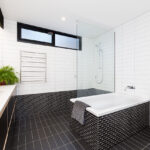 the contrasting black and white tiling gives the bathroom a modern and sophisticated look