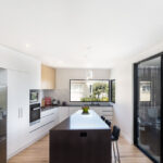 the granite benchtop is the feature of this modern kitchen