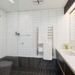 all of the bathrooms in the development have a combination of mosaic and plain tiles, adding interest and originality