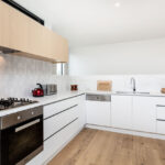 the oak engineered floorboards, contrasting joinery and marble & tiled splashbacks work exceptionally well together in this kitchen